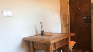A wooden desk with a woven basket and a bottle of reed sticks. - Appartamento Volta Della Vecchia (Florence)