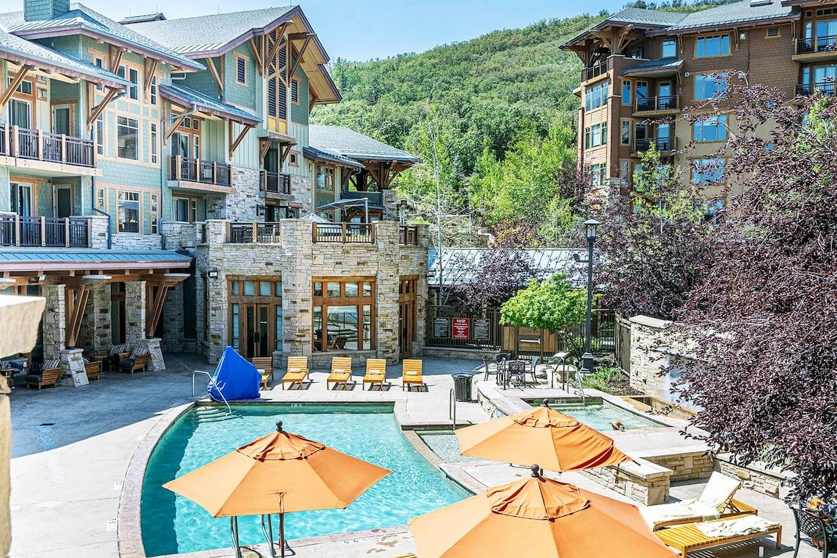 A resort with a pool area, outdoor seating, and multiple buildings with balconies.