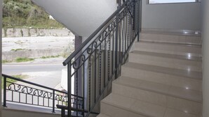 A staircase with a metal railing leading to a landing. - Helena Apartments (Budva)