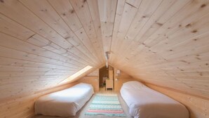 A cozy attic bedroom with two single beds, a wooden ceiling, and a small hallway. - Klemskerkestraat with terrace by Interhome (Bredene)