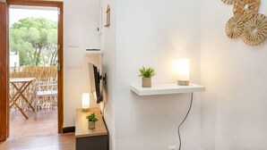 A modern room with a wooden desk, a small plant, and a wall-mounted shelf with a lamp.