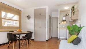 A modern apartment with a dining area, a kitchen, and a living room.