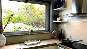 A kitchen with a window, a sink, a stove, and a countertop. - Villa Mica in La Maddalena (La Maddalena)