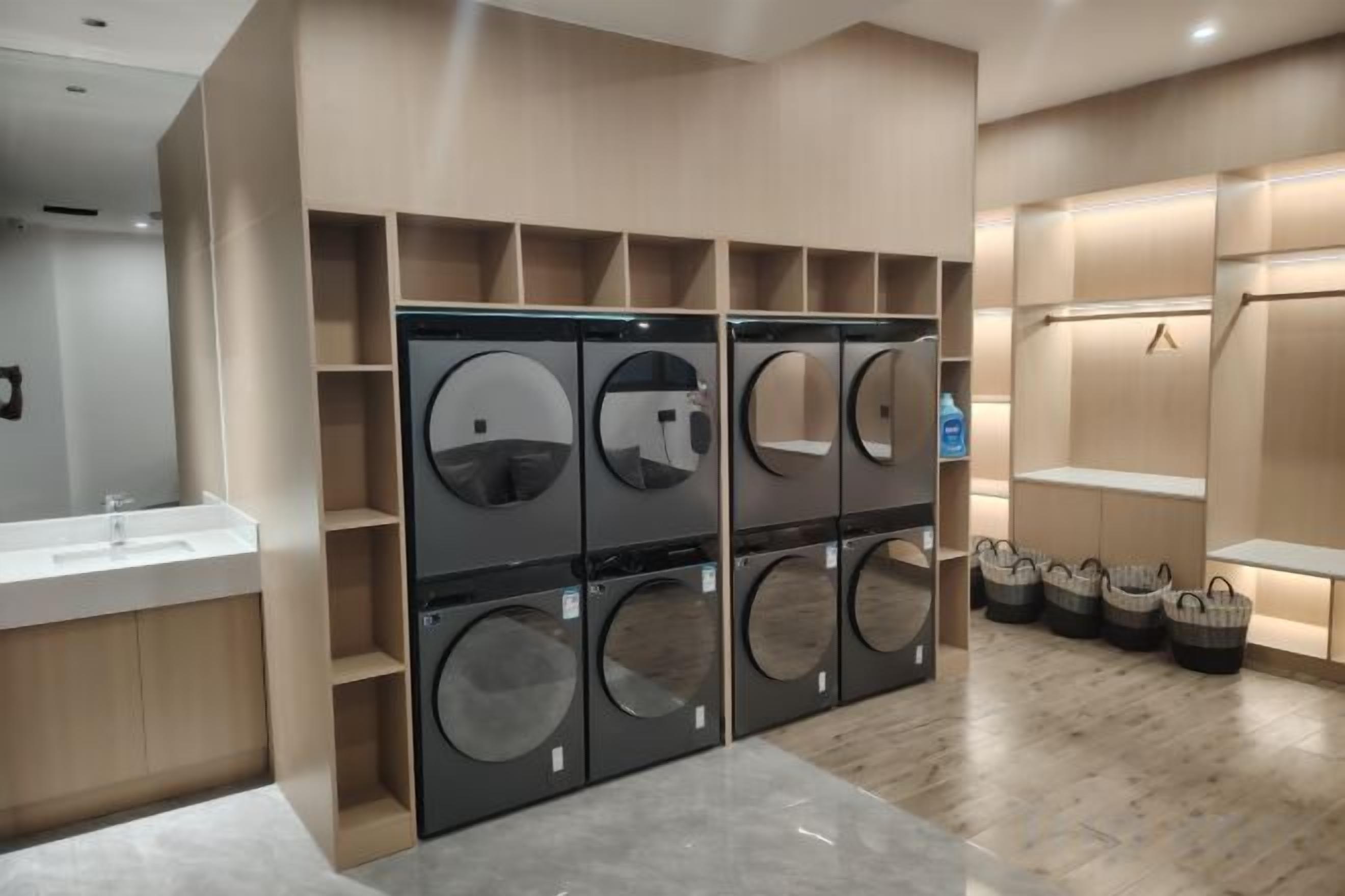 A modern laundry facility with multiple washing machines and drying racks.