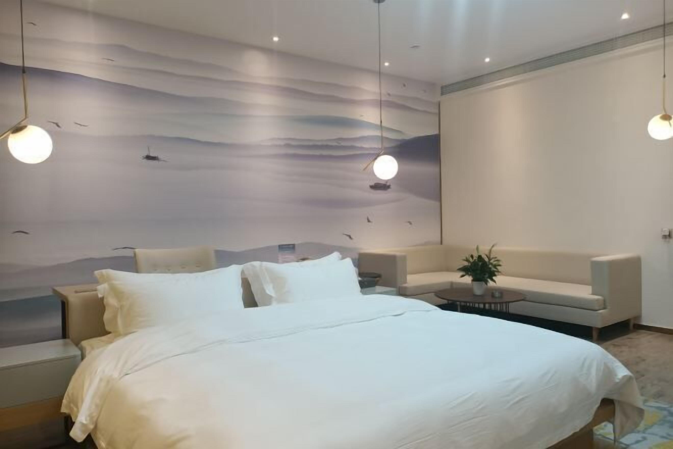 Une chambre à coucher comprenant un lit, un canapé, une table basse et une fresque murale.