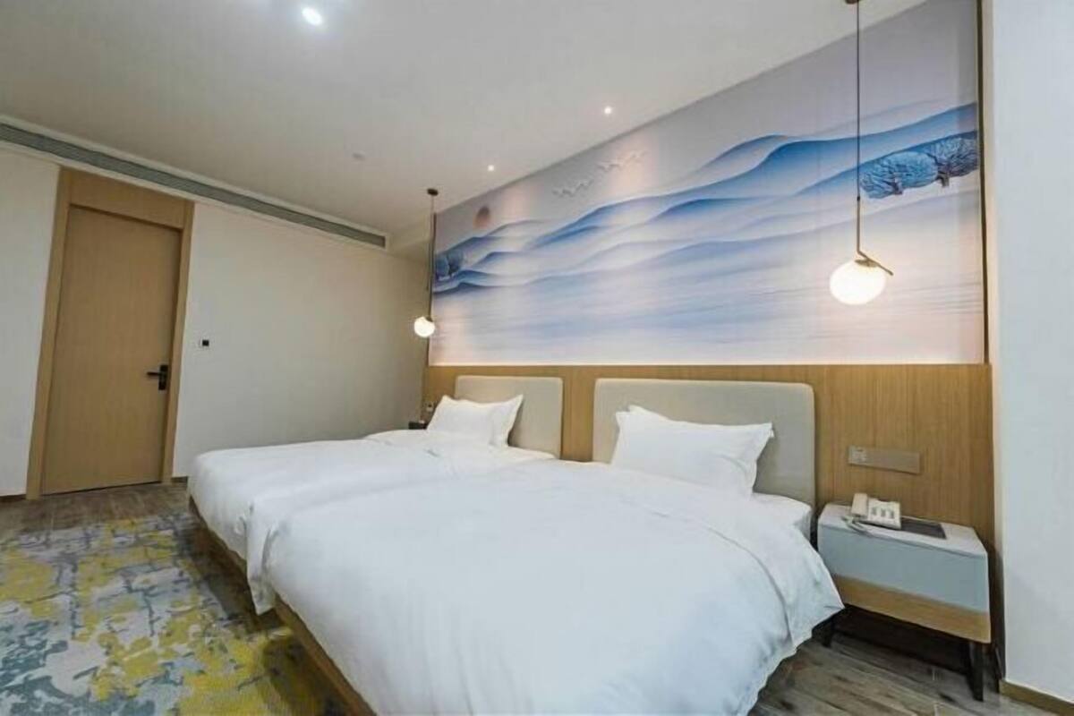Relax in comfort with a large bed, two nightstands, and a serene wall art above.