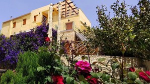 Un edificio con facciata in pietra, una scala in legno e un balcone.