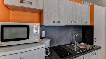 Een koelkast, een microgolfoven, een kookplaat, een waterkoker