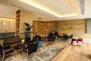 A spacious lobby with a reception desk, seating area, and a large bookshelf. - Fragrans Hotel(Suzhou Lumu Metro Station Branch) (Suzhou)