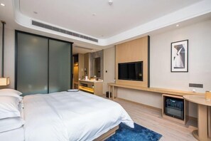 A modern hotel room with a large bed, a TV, a desk, and a minibar. - Fragrans Hotel(Suzhou Lumu Metro Station Branch) (Suzhou)