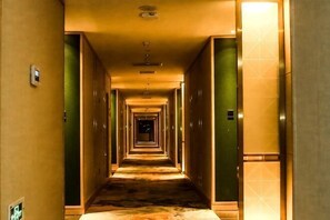 Ein langer, schmaler Hotelgang mit Türen an beiden Seiten zu Zimmern.