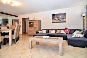Un salon comprenant un canapé, une table basse et un coin repas avec des chaises et une table.