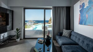 A modern living room with a large sliding glass door leading to a pool and ocean view. - Made By The Sea Villa 3 (Malevizi)