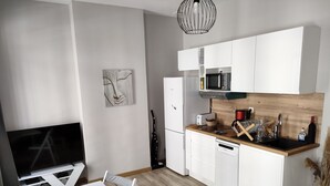A modern kitchen with white cabinets, a microwave, a toaster, and a sink. - Newly renovated apartment Joliette Marseille (Marseille)
