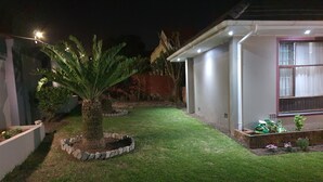 Een verzorgde tuin met een centrale palmboom, omgeven door een stenen rand.