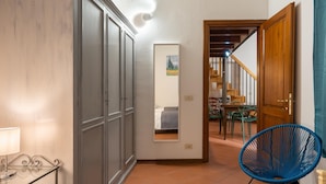 A bedroom with a bed, a wardrobe, a mirror, and a chair. - Appartamento Via Dell Oriuolo (Florence)