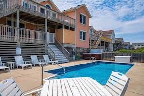 A swimming pool with lounge chairs and a wooden deck. - Barefootin'- Oceanfront, private pool, hot tub, pool table, private walkway to the beach! (Nags Head)