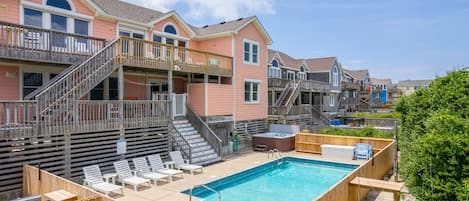 Área residencial com piscina, deck de madeira e várias casas de dois andares com varandas.