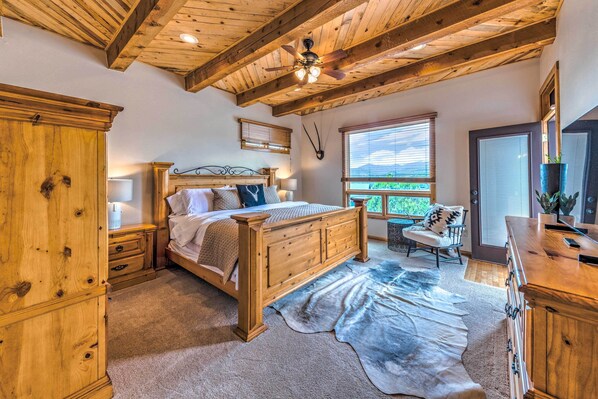 Une chambre à coucher avec un lit en bois, un bureau, une chaise et une grande fenêtre.