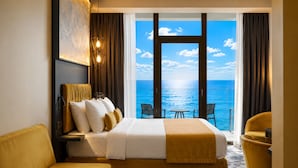 A hotel room with a bed, a sofa, a table, and a view of the sea. - Miramare Magnetic Beach Hotel (Kobuleti)