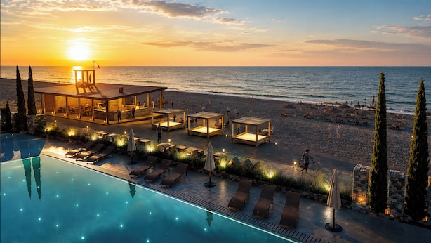 A poolside area with lounge chairs and a bar, overlooking a beach at sunset. - Miramare Magnetic Beach Hotel (Kobuleti)