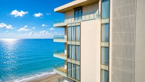 A modern building with large windows and balconies overlooking a beach. - Miramare Magnetic Beach Hotel (Kobuleti)