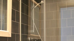 Une salle de bain moderne avec une douche à parois de verre, un lavabo blanc et un meuble en bois.