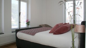 A bedroom with a bed, a window, and a lamp. - De Torre 1 - luxury 1-bedroom apartment in iconic building (De Haan)