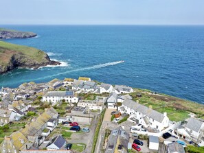 Un village côtier aux bâtiments blancs, avec une rue étroite et une vue sur la mer.