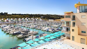 A swimming pool with a tiled deck, surrounded by a marina with boats. - Modern luxury apartment on the Albufeira Marina (Albufeira)