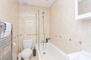 A bathroom with a toilet, a bathtub, and a shower.