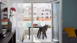 Uma varanda com uma mesa, cadeiras e um sofá.