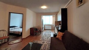 Een knus woongedeelte met een bank, een eettafel en een kitchenette.