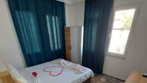 A room with a bed, a desk, and a wardrobe. - Bella Rose Hotel (Fethiye)