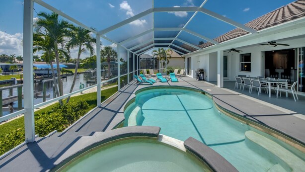 Une piscine couverte avec des chaises longues et un espace patio.