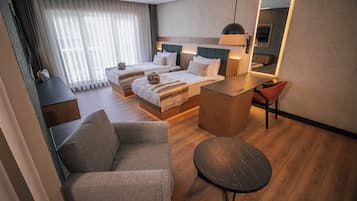 Une chambre d’hôtel avec deux lits, un coin salon, une petite table et un miroir.