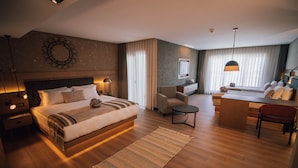 A modern hotel room with a large bed, a desk, and a comfortable seating area. - Panagia Premier Trabzon (Trabzon)