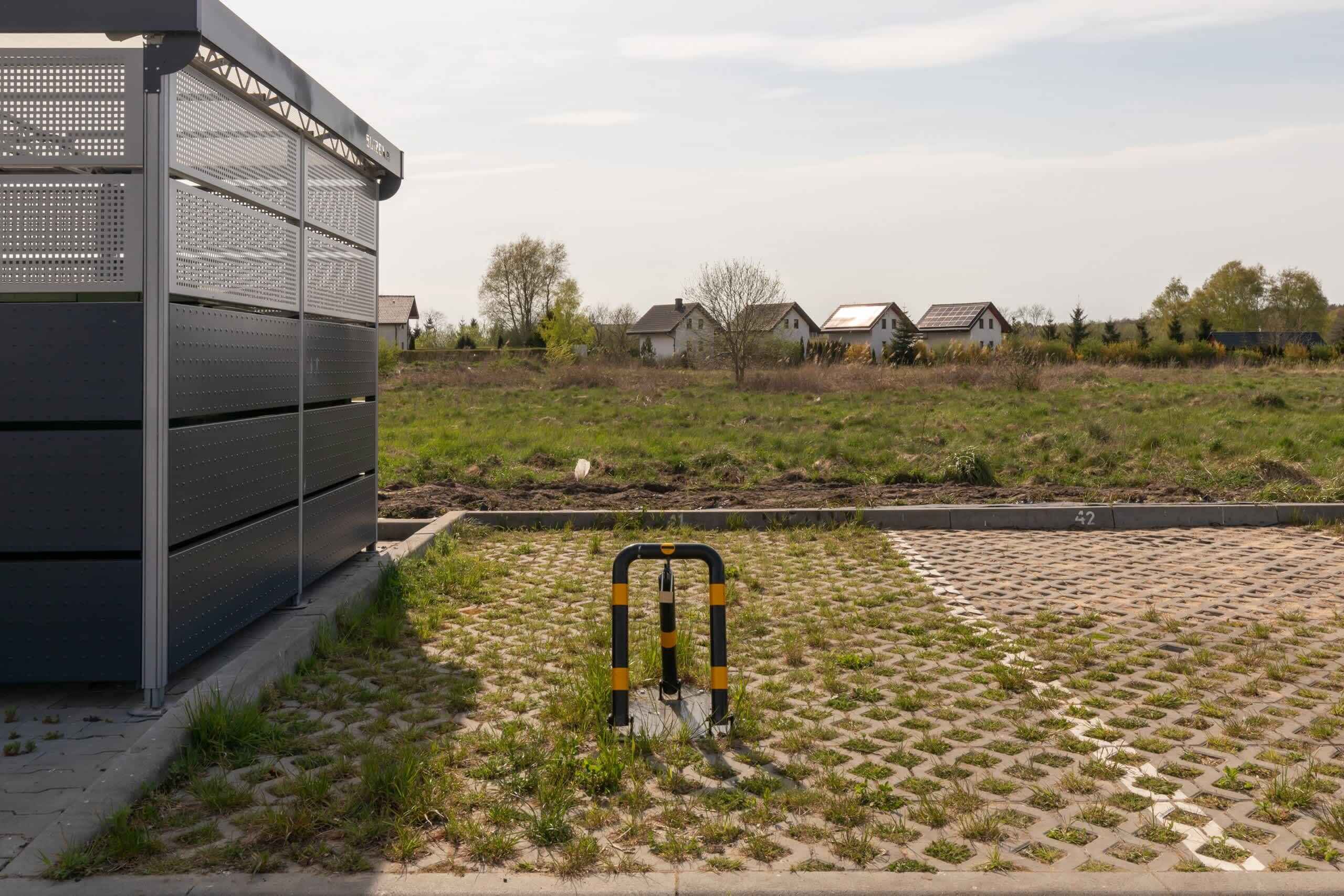 A building with a metal facade and a paved area with a bollard.