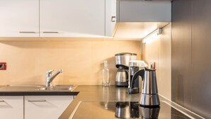 A modern kitchen with a stainless steel sink, a coffee maker, and a kettle on the counter. - Apartment 'Prapoz Typ B1' with Mountain View, Shared Garden & Wi-Fi (Ortisei)