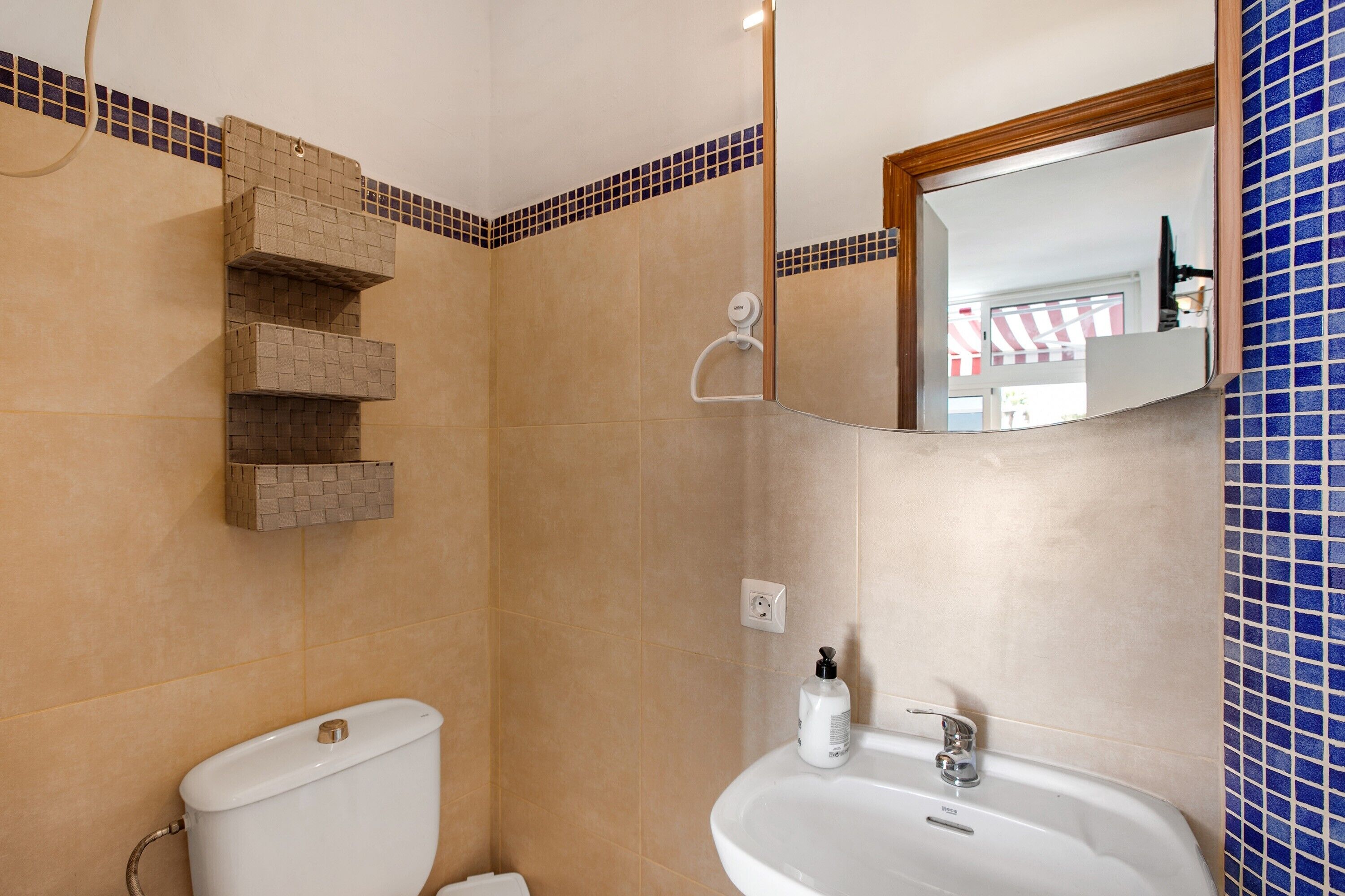 Een badkamer met toilet, wastafel en douche.