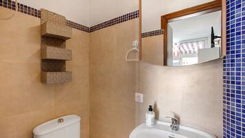 Een badkamer met toilet, wastafel en douche.
