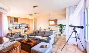 Un salon moderne comprenant un canapé, une table basse et un coin repas avec une table et des chaises.