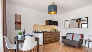 Et moderne køkken med spiseplads, en sofa og et lille sofabord.