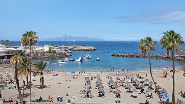 A beach with palm trees, umbrellas, and boats. - Holiday Home 'Estudio 4 Costa Adeje' with Wi-Fi (Adeje)