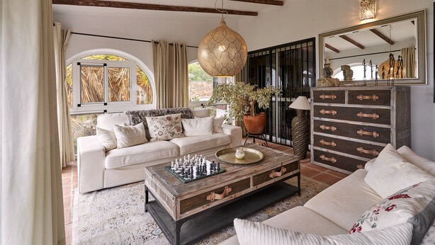 Uma sala de estar com sofá, mesa de centro e um tabuleiro de xadrez.