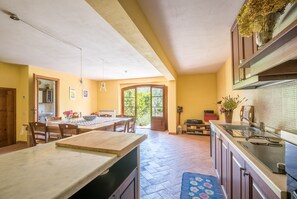 Une cuisine avec un coin repas, une grande fenêtre et un pare-feu en carreaux.