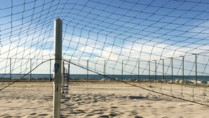 A beach volleyball court with a net, sand, and a view of the ocean. - Apartment for couples, Alex 1, near the sea in Umag (Umag)