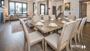 A spacious dining area with a wooden table set for six, surrounded by upholstered chairs.