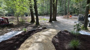 Ein bewaldetes Gebiet mit einem Steinweg, der durch eine Lichtung führt.