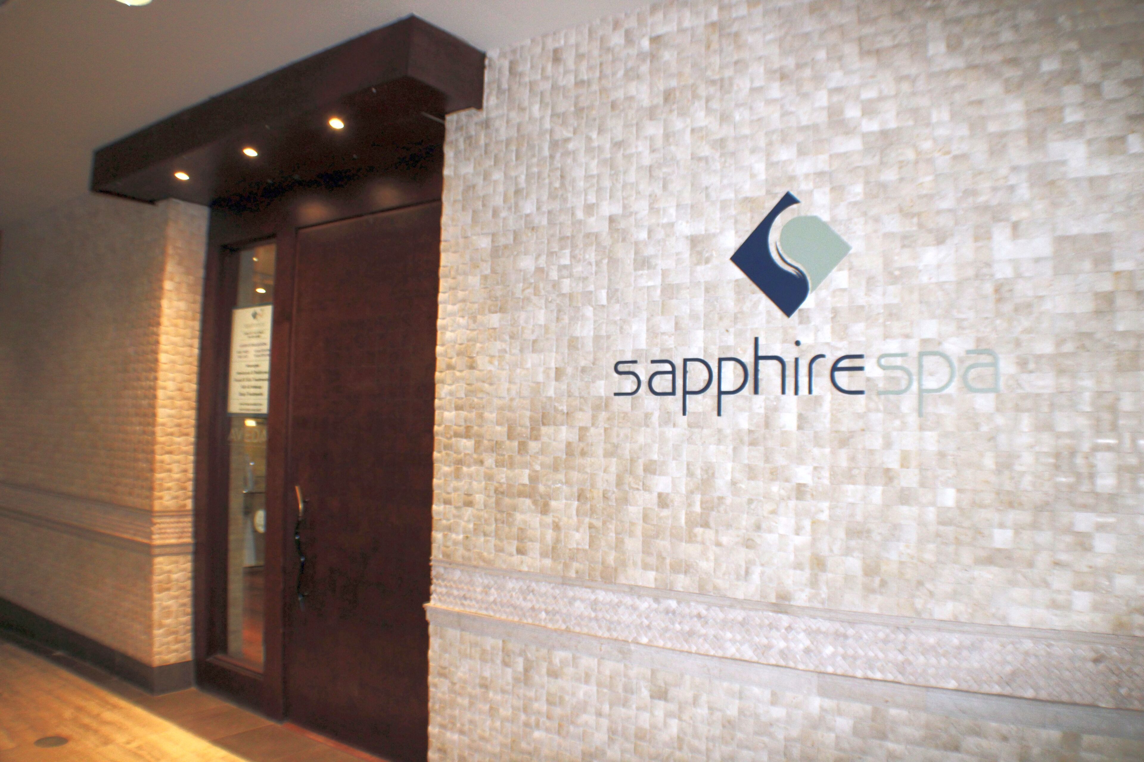 A spa entrance with a textured wall and a wooden door.